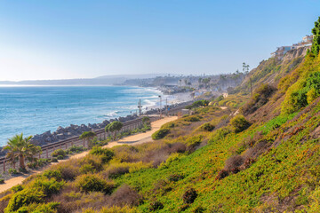 View of the beach and train tracks from the top of a mountain slope in San Clemente, California - obrazy, fototapety, plakaty