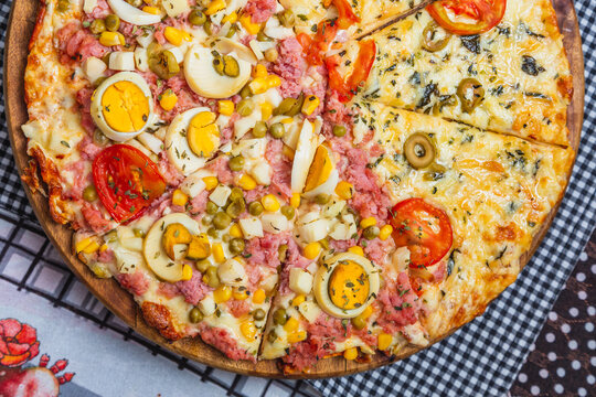 Portuguese pizza and margarita pizza together in one pizza. sliced ​​and divided, baked pizza, home pizza.