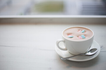  A cup of cocoa with marshmallows in a cafe on a wooden table