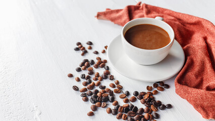 coffee cup and coffee beans on white wooden background