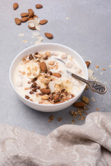 Healthy breakfast of granola with fresh banana, nuts and yogurt