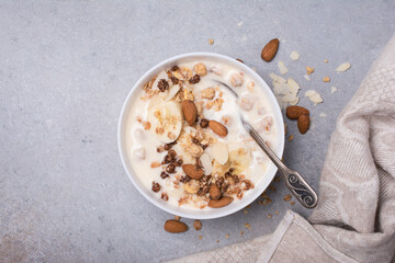 Healthy breakfast of granola with fresh banana, nuts and yogurt