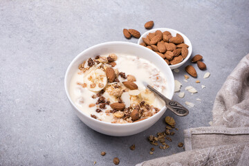 Healthy breakfast of granola with fresh banana, nuts and yogurt