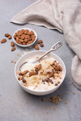 Healthy breakfast of granola with fresh banana, nuts and yogurt