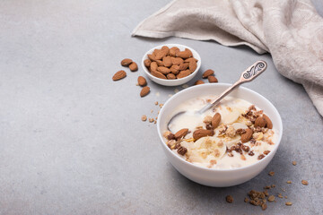 Healthy breakfast of granola with fresh banana, nuts and yogurt
