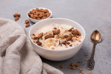 Healthy breakfast of granola with fresh banana, nuts and yogurt
