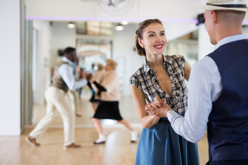 Cheerful female practicing lindy hop in pair with man