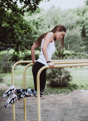 Healthy and sporty concept. Sporty fitness woman doing push-ups on parallel bars while training outdoors.