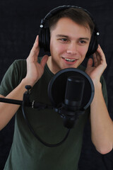 The guy plays the guitar sings into the microphone