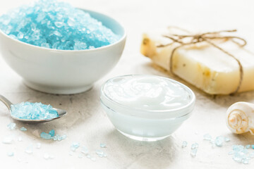 Fototapeta na wymiar set for bath with blue salt and shells on stone table background