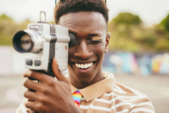 Young african man using vintage old video camera outdoor