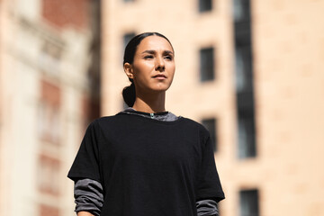 Fototapeta premium Portrait of serious confident pretty millennial arabic woman athlete in sportswear looks towards empty space