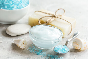 Fototapeta na wymiar Home cosmetic with cream and blue sea salt on stone background