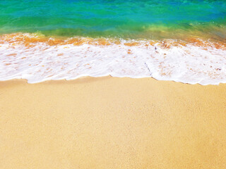 Turquoise blue sea wave on white sand of tropical beach. Soft waves of blue sea and the sand texture of the French West Indies. Wallpaper. Gentle blue ocean wave on a clean sandy beach.