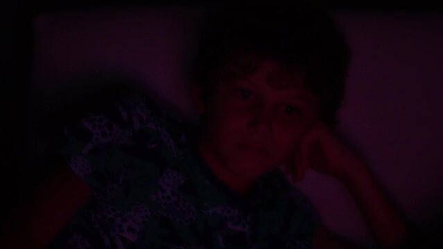 Boy hypnotized by movie at night watching film