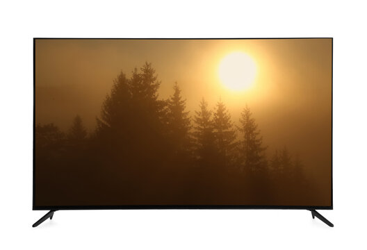 Modern wide screen TV monitor showing foggy forest at sunrise isolated on white