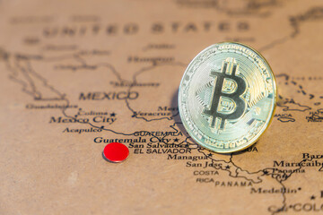 Bitcoin symbol  standing on the world map, El salvador is pinned on the map