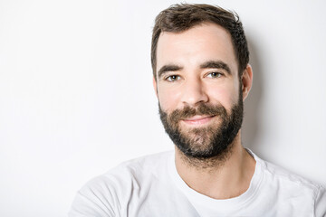 portrait of casual young man with beard on white background