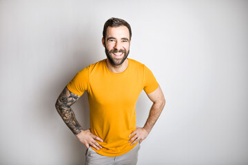 portrait of casual young man with beard and tattoo and Burnt Orange shirt on white background