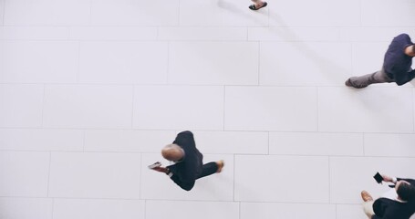 Moving around like busy ants. Overhead of a group of business people walking around on a busy day in a modern office. Diverse crowd walking through a convention at a conference from above