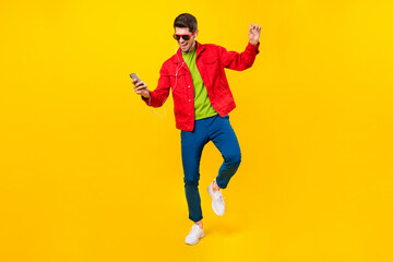 Fototapeta na wymiar Full length body size view of attractive trendy guy listening hit having fun isolated over bright yellow color background