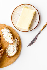 Slice of bread with butter on white table