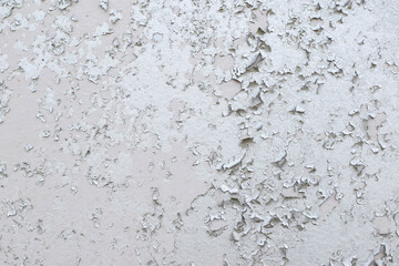 Old gray paint peeling from wall texture background. Cracked paint on metallic background
