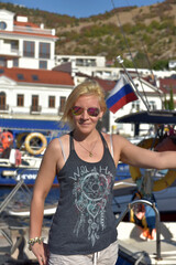 woman in summer in a T-shirt and shorts on the mooring of boats