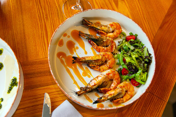 Appetizing fried shrimp in mustard sauce with fresh vegetables