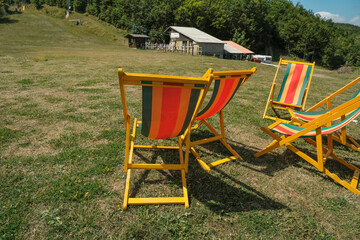 Couple of orange striped un beds on the grass across the mountains. relax on the fresh air. outdoor activity. Monte Ventasso,  Reggio Emilia, Italy  