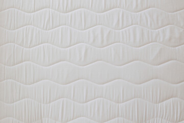 Close up shot of white orthopedic mattress top side surface pattern with a lot of copy space for text. Hypoallergenic foam matress for proper spinal alignment and pressure point relief. Background.