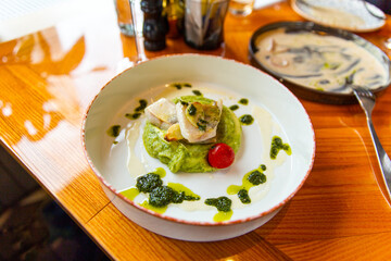 Baked zander fillet with herbs, combined with mashed potatoes with pesto. Garnished with wine sauce