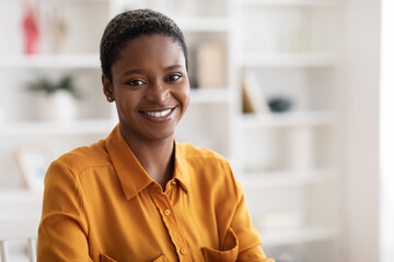 Portrait of happy young black woman posing at office