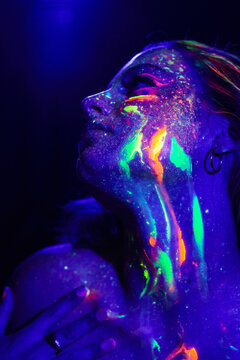 Charming woman with neon lights in darkness