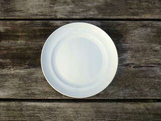 empty white plate on wooden table