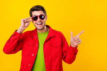 Photo of cool millennial guy index promo wear glasses red jacket isolated on yellow color background