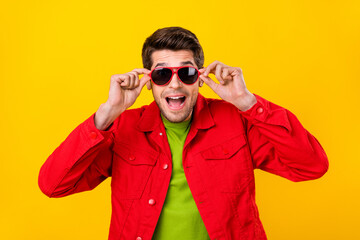 Photo of hooray young guy hold eyewear wear red shirt isolated on yellow color background