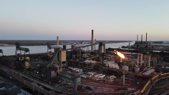 Steel mill with flames coming out of flare tower, Aerial orbit shot, Zug Island, Detroit, Michigan