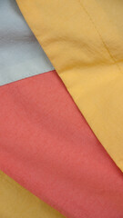 Detalle de chándal de polyester de colores blanco, amarillo y rosa
