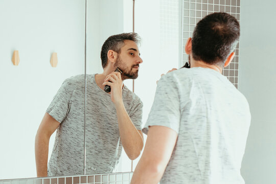 Man shaving beard with trimmer