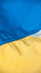 Detalle de chándal de polyester de colores azul, blanco y amarillo