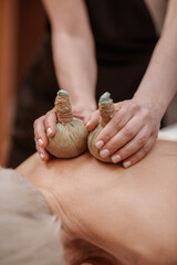 Obraz na płótnie Canvas Professional doing hot bags massage to a client