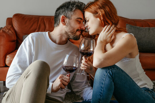 Loving couple with wineglasses on floor