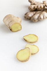 Fresh ginger root and slice isolated on white background. Selective focus.