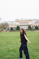 Fototapeta premium young joyful woman in sleeveless jacket in green park.