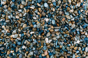 Mosaic sea pebbles background. Texture of small marine multi-colored pebbles.