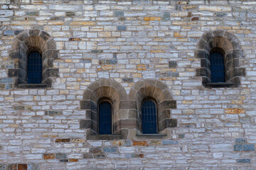 Fototapeta na wymiar Arched windows in a stone wall. Old antique church.