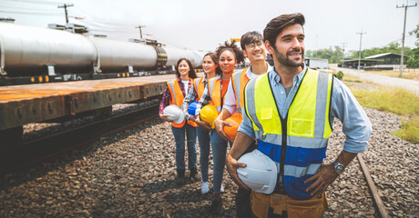 Team railway engineer holding helmet standing in row on site work.