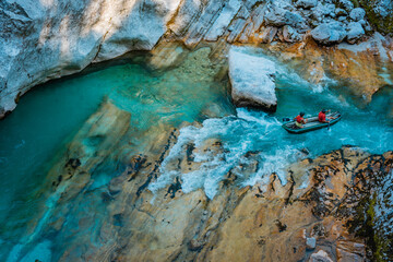 Beautiful shot of a people on a boat rafting on the rocky transparent river