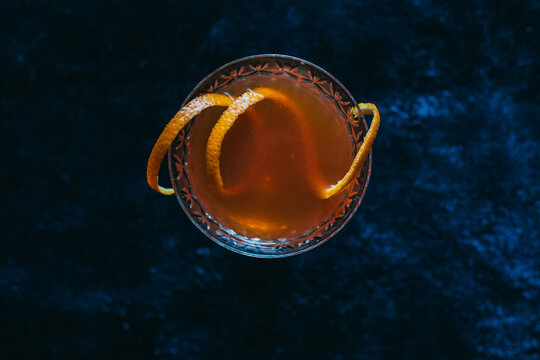 top down shot of orange cocktail on blue rug
